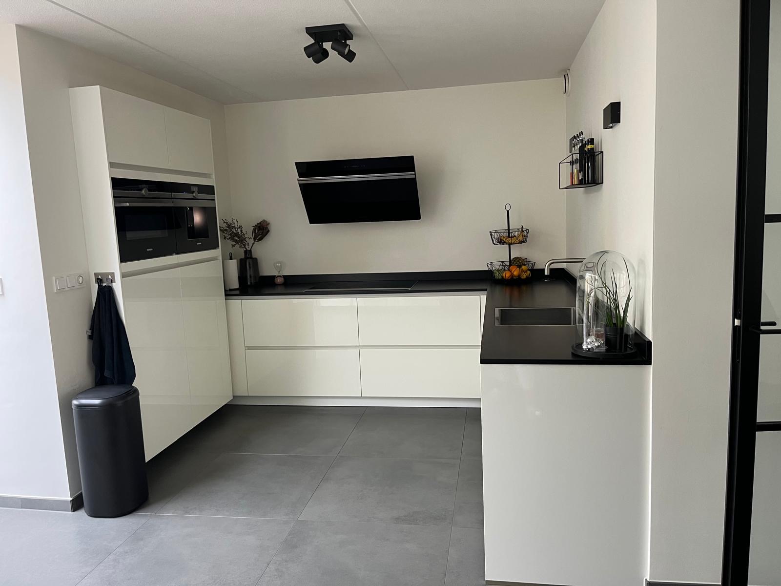 Keuken gewrapt in wit glans met zwart werkblad