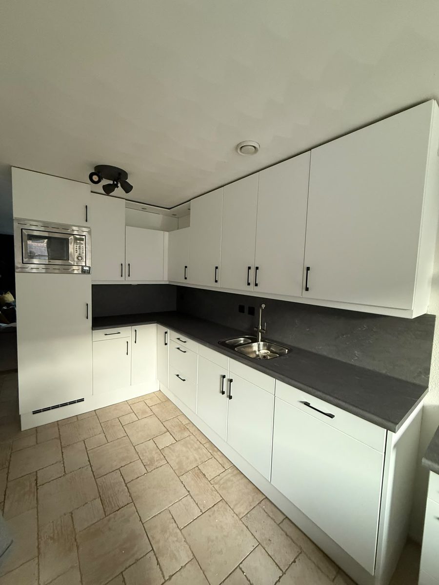 Keuken na renovatie: strak mat wit gewrapt met donker werkblad door WrapByDjam