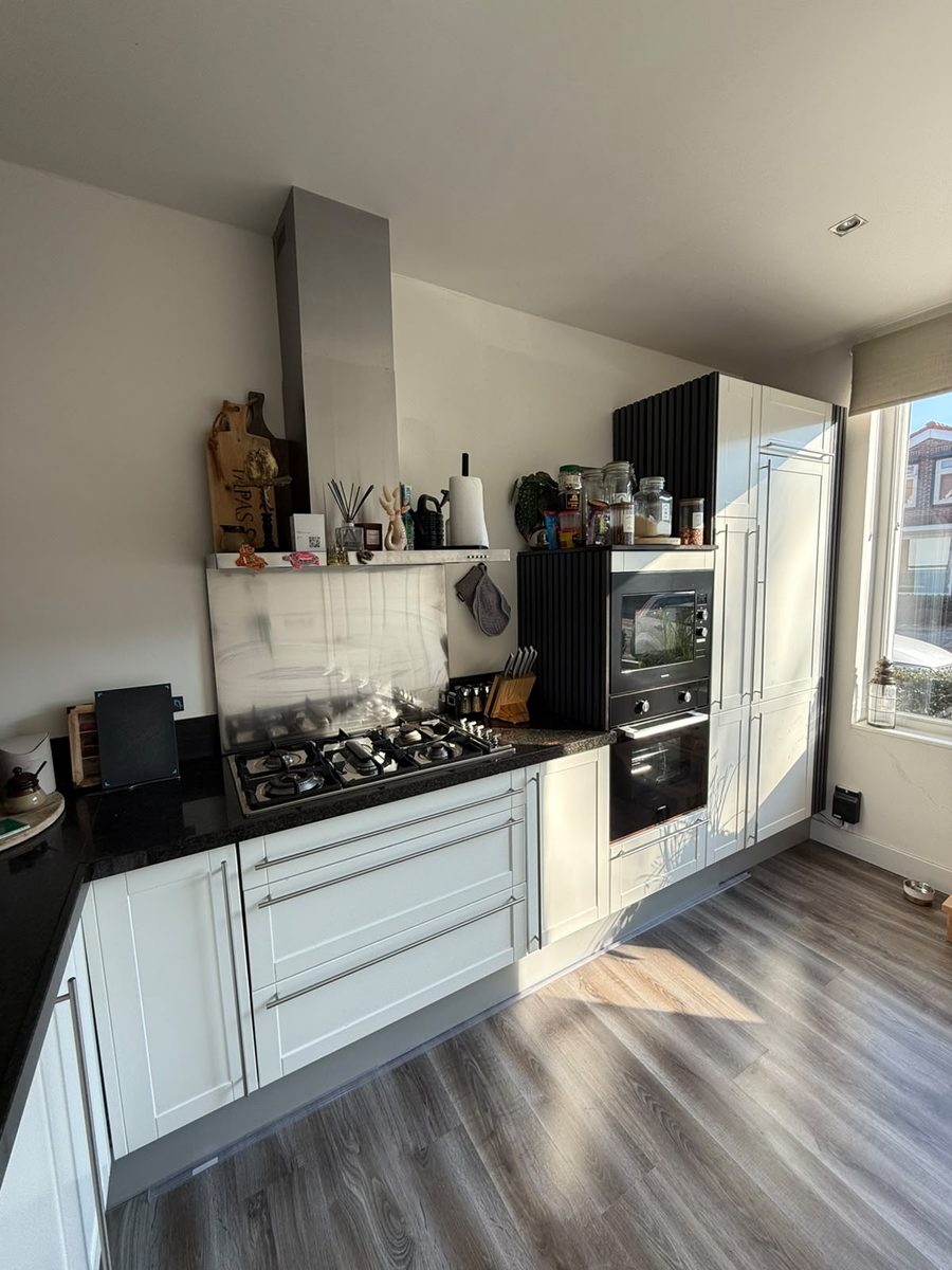 Keuken voor renovatie: witte keuken met zwart granieten werkblad